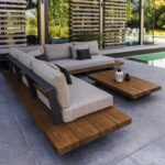Modern wooden outdoor sofas with grey cushions and a matching coffee table on a patio.